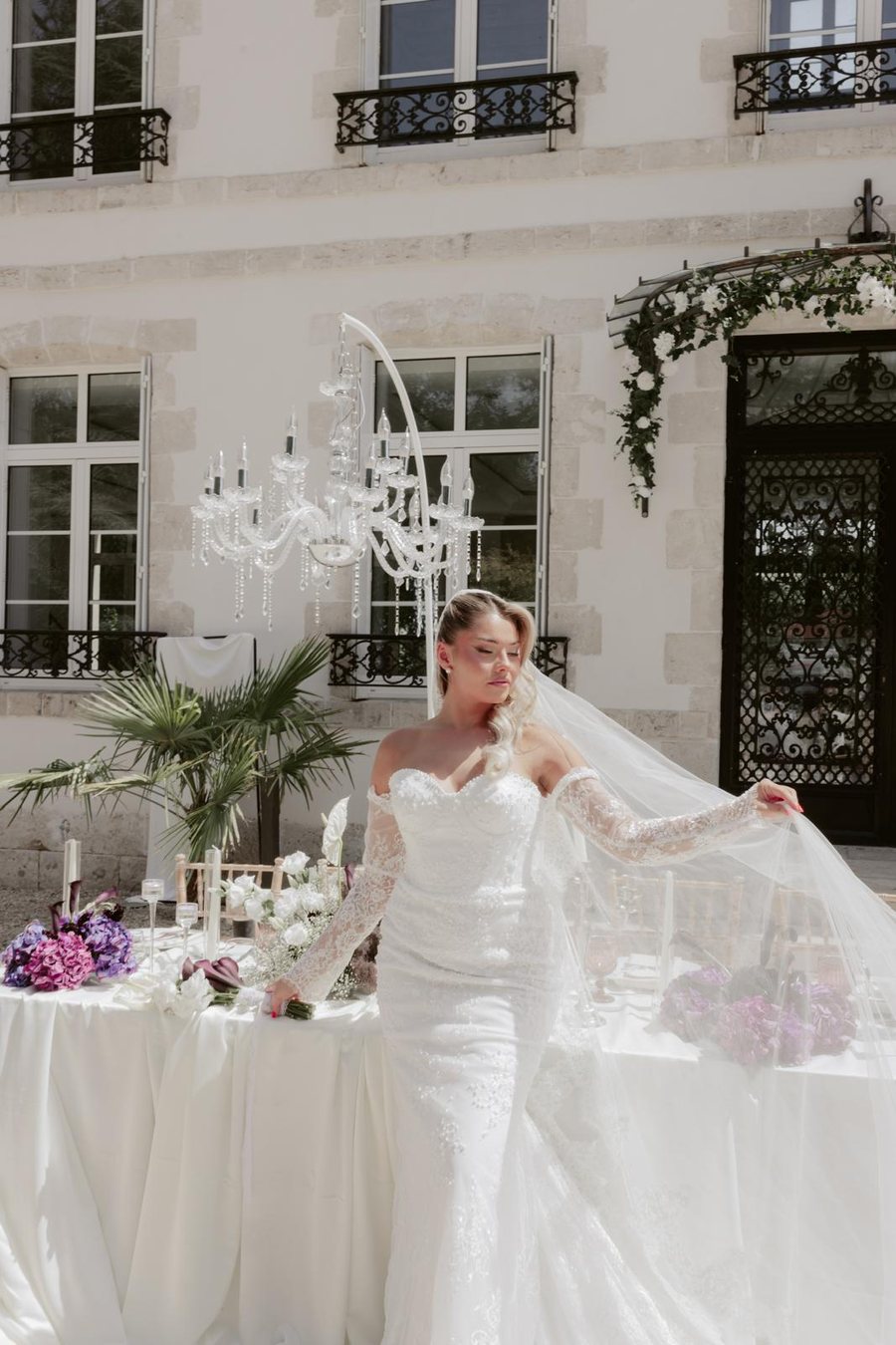 Mariée assise sur les marches d'un escalier en pierre, robe bustier