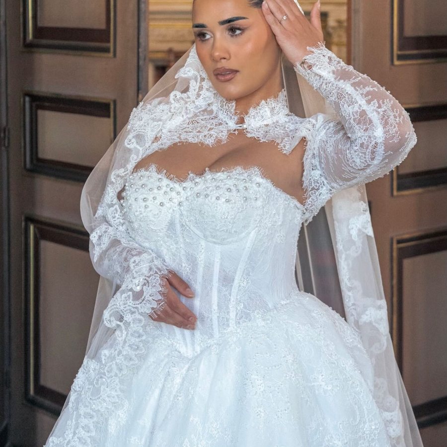 Robe de mariée à jupe ample et manches en dentelle, dans un salon d'honneur
