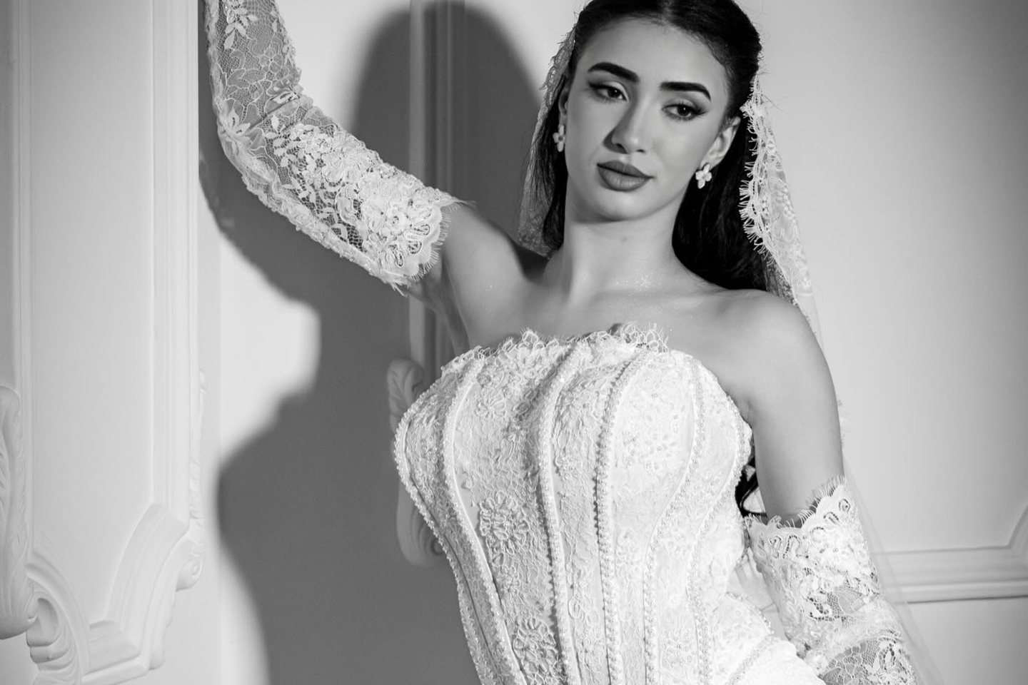 Mariée en robe longue traversant une galerie, silhouette saisie en mouvement